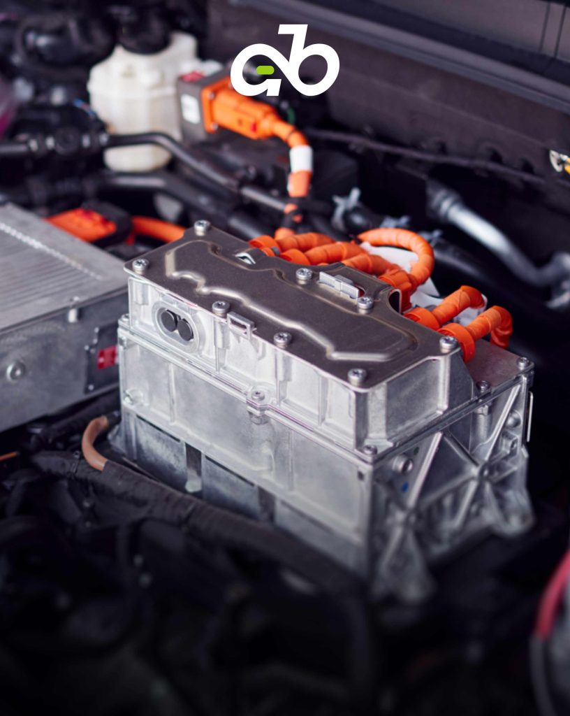Hochspannungs-Leistungselektronik- und Wechselrichtermodul, das in einem Motorraum eines Elektrofahrzeugs installiert ist und über eine strapazierfähige orangefarbene Hochspannungskabel verfügt.