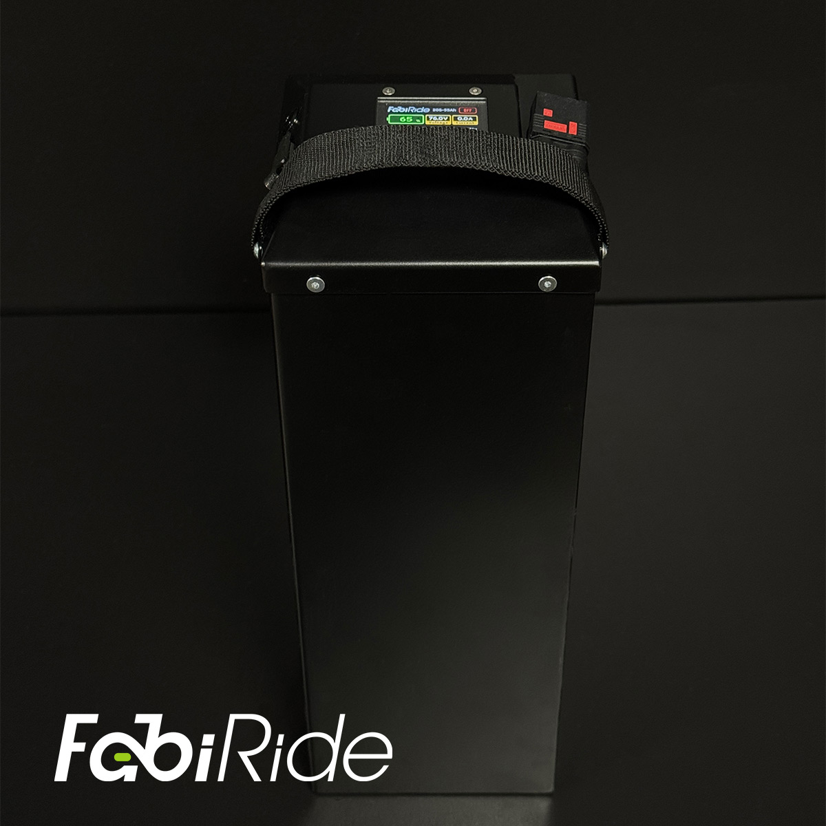 Juodas elektrinis krosinis motociklas su geltonais akcentais žalios sienos fone.