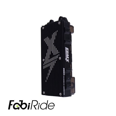 Juodas elektrinis krosinis motociklas su geltonais akcentais žalios dirbtinės žolės sienos fone.